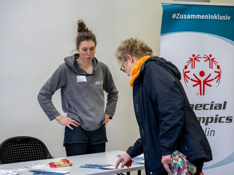 Eine Besucherin schaut sich Infomaterialien am Stand von Special Olympics Berlin an.